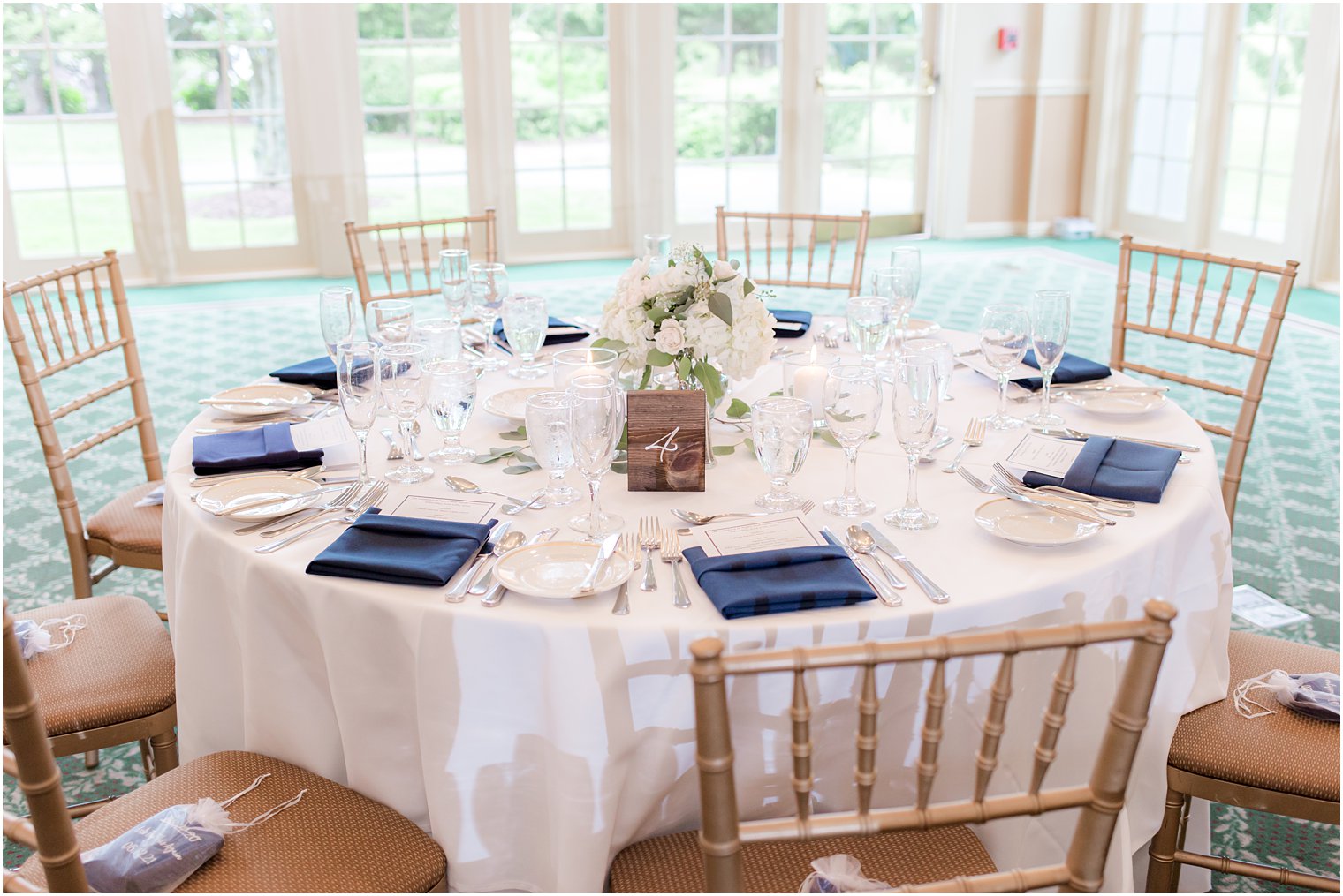 table setting with navy napkins and ivory flowers at Forsgate Country Club