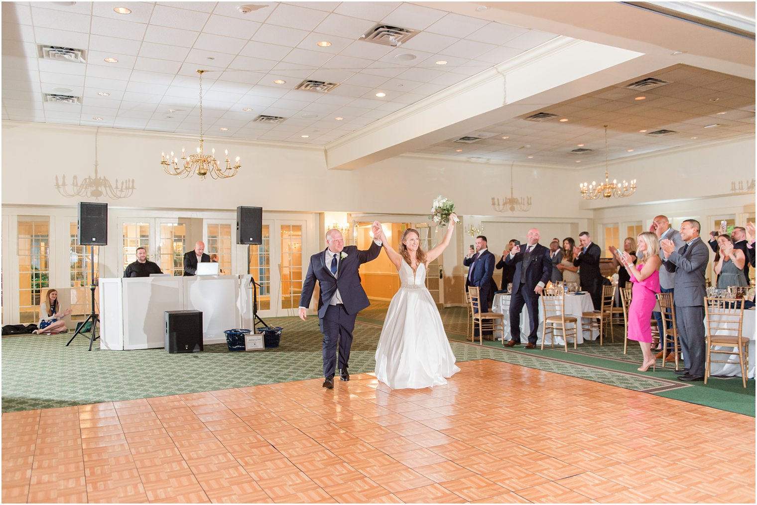 newlyweds enter Forsgate Country Club wedding reception cheering on dance floor