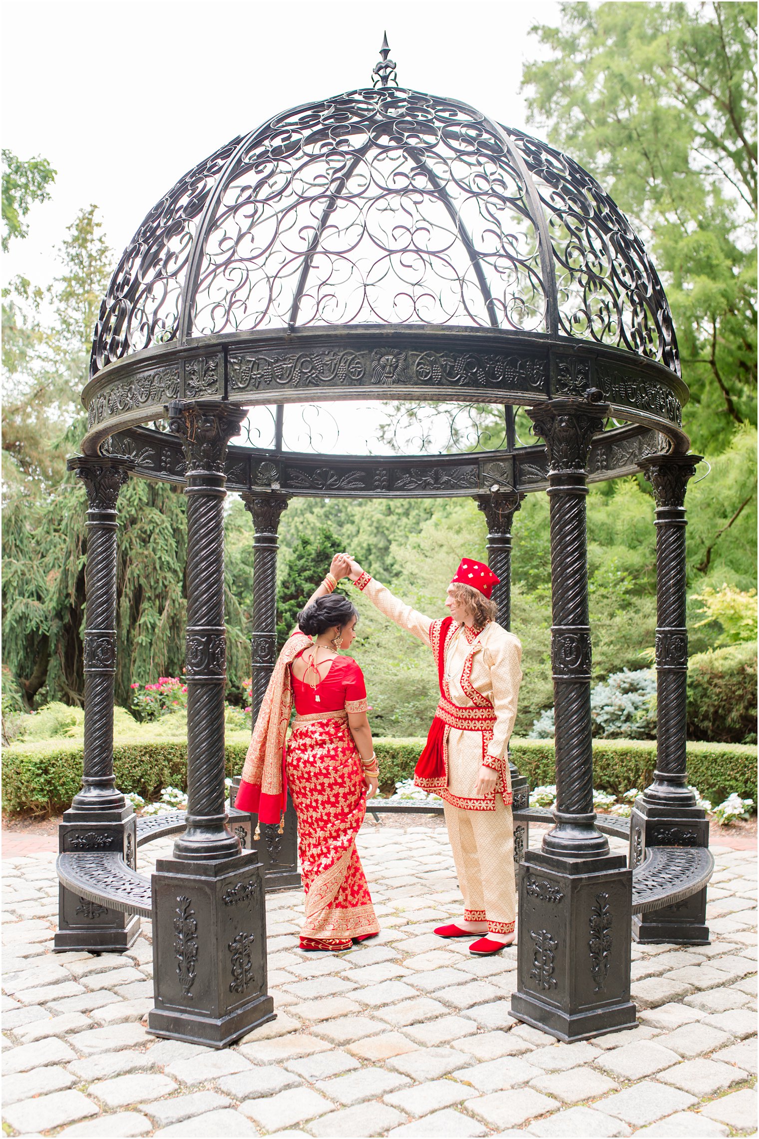 groom twirls bride under gazebo at Ashford Estate in traditional Indian wedding attire 