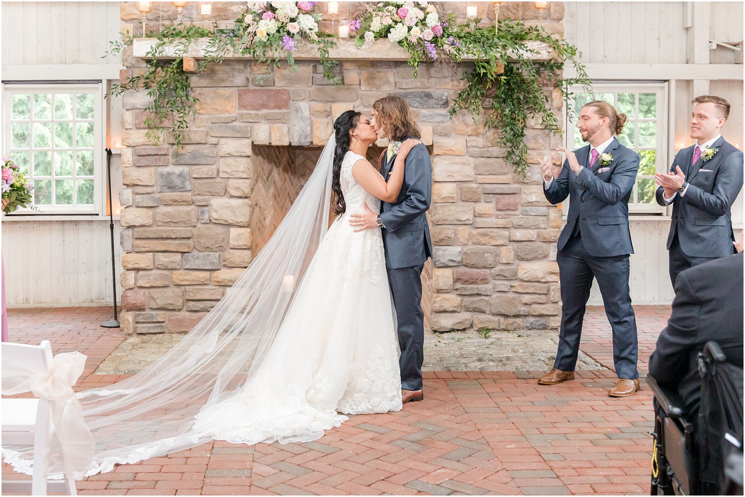 newlyweds kiss during Ashford Estate wedding ceremony by fireplace 