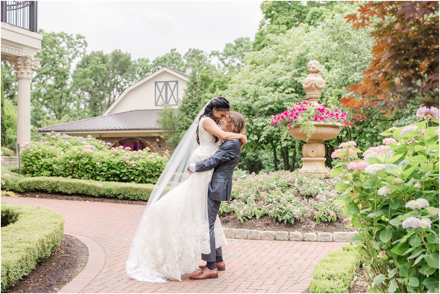 groom lifts bride up in gardens of Ashford Estate