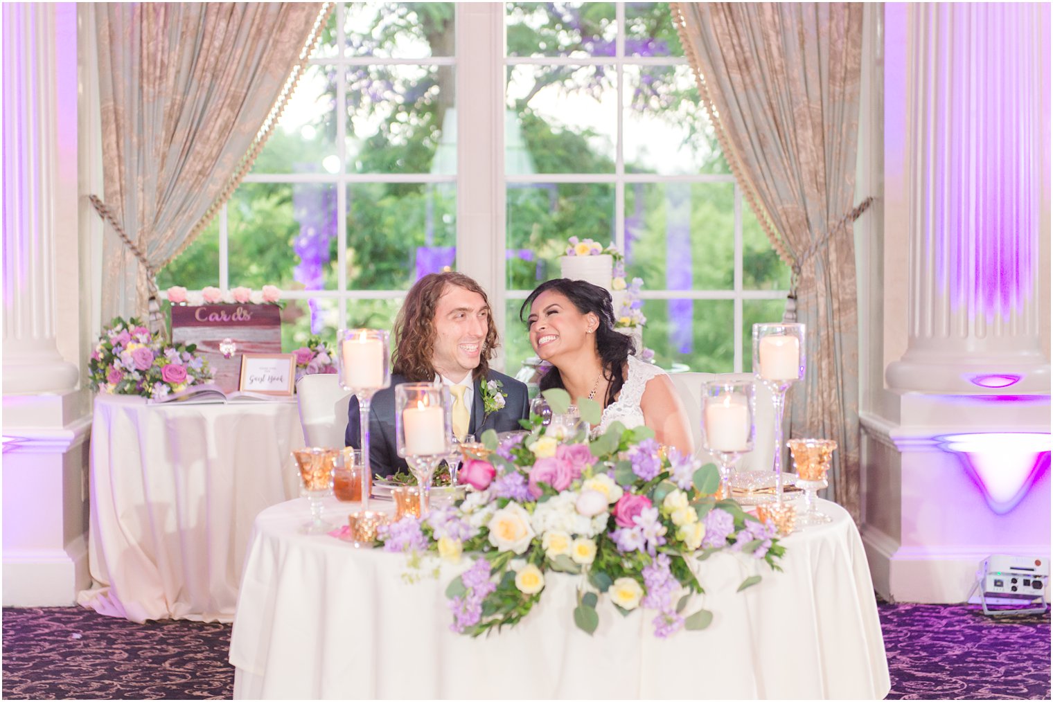 newlyweds sit together at sweetheart table during NJ wedding reception 