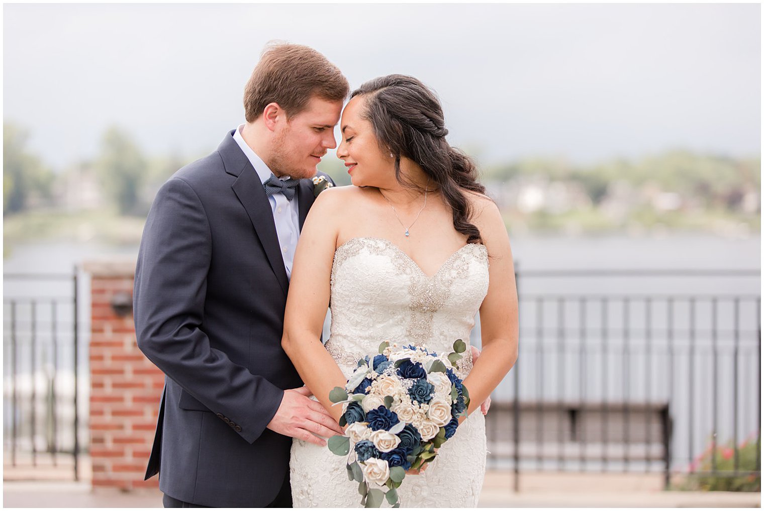 newlyweds stand together on walkway in Red Bank NJ with foreheads touching 