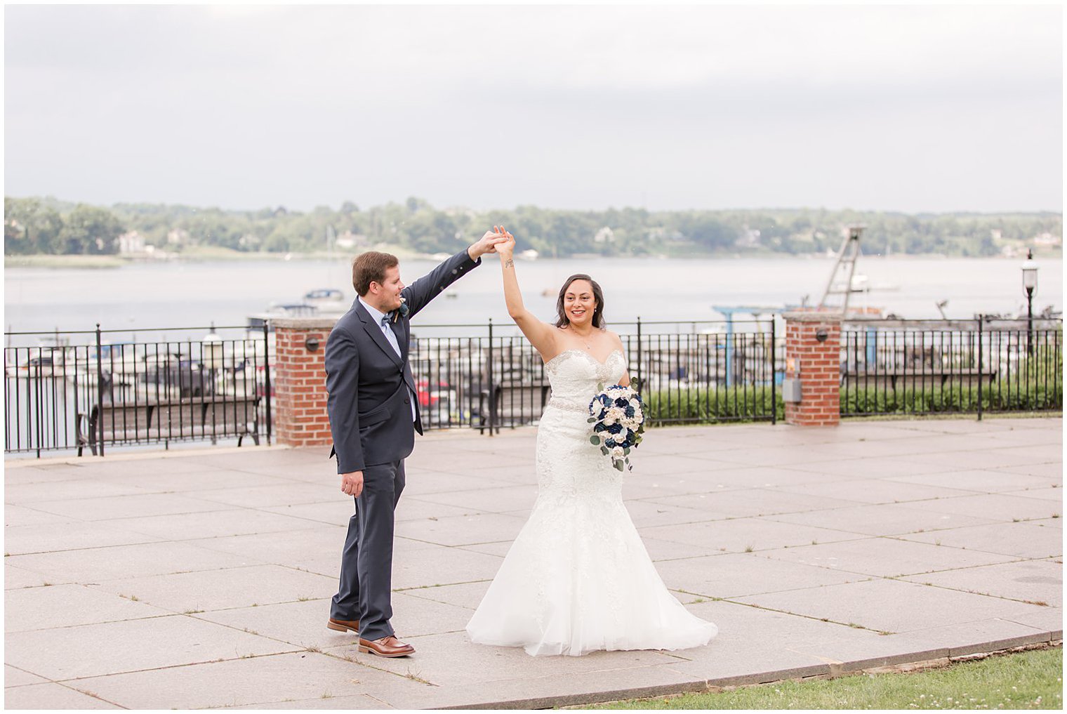 groom twirls bride before Red Bank, NJ wedding along waterfront 