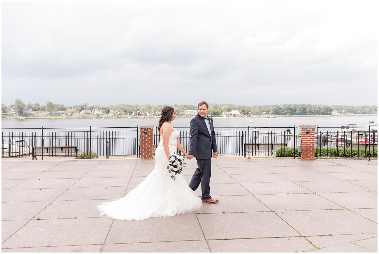 bride and groom hold hands walking through Red Bank, NJ