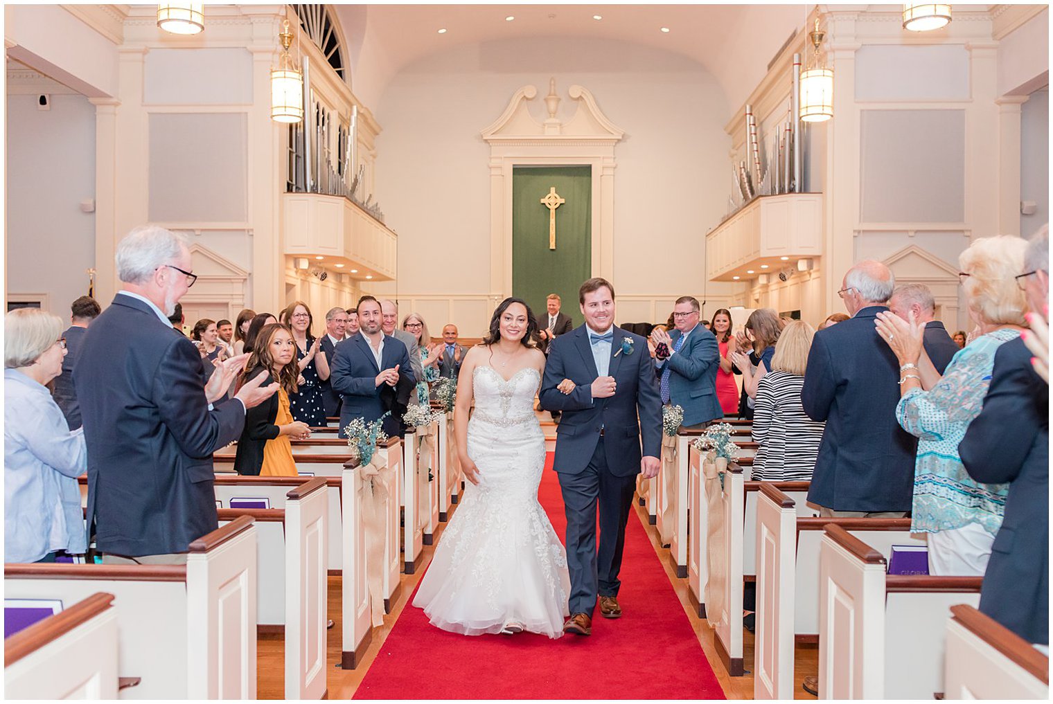 married couple walks up aisle after traditional church wedding in Red Bank New Jersey 