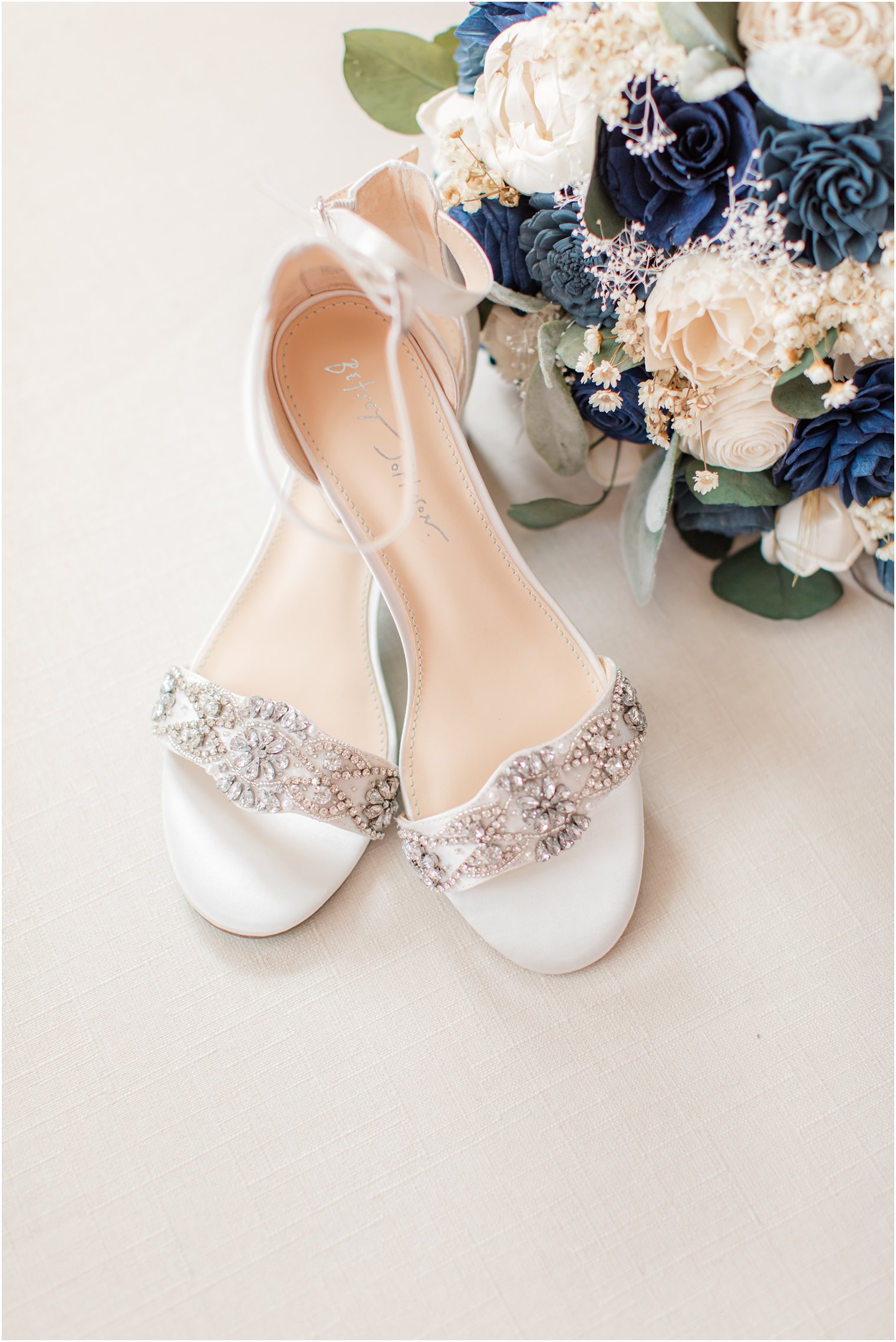 bride's shoes with bouquet of white and blue wooden flowers 