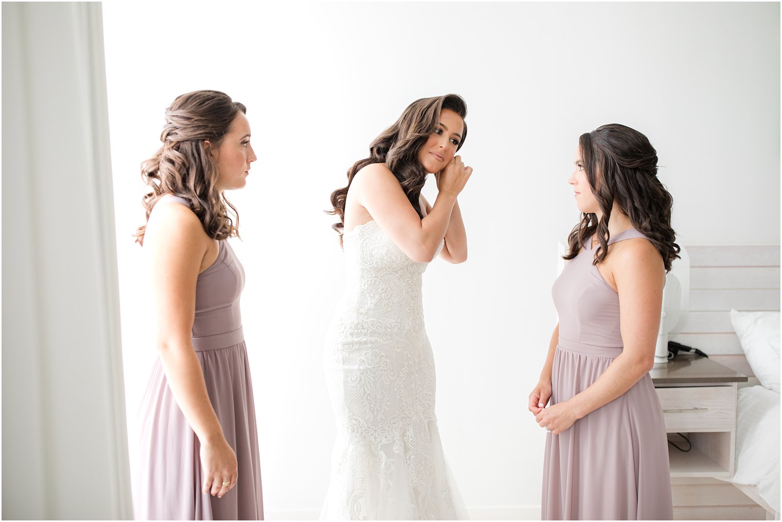 bride adjusts earrings during prep for NJ wedding day