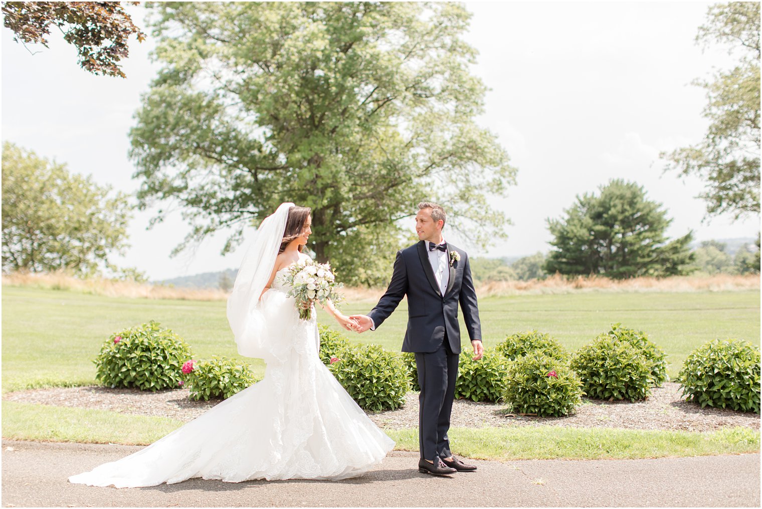 bride and groom hold hands walking through Navesink Country Club