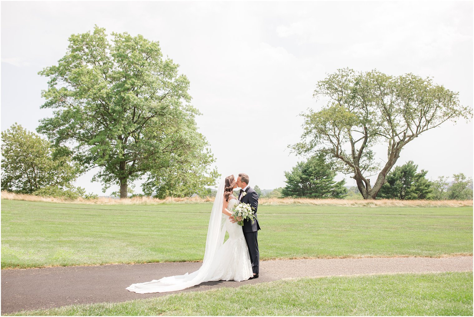 bride and groom kiss on green at Navesink Country Club