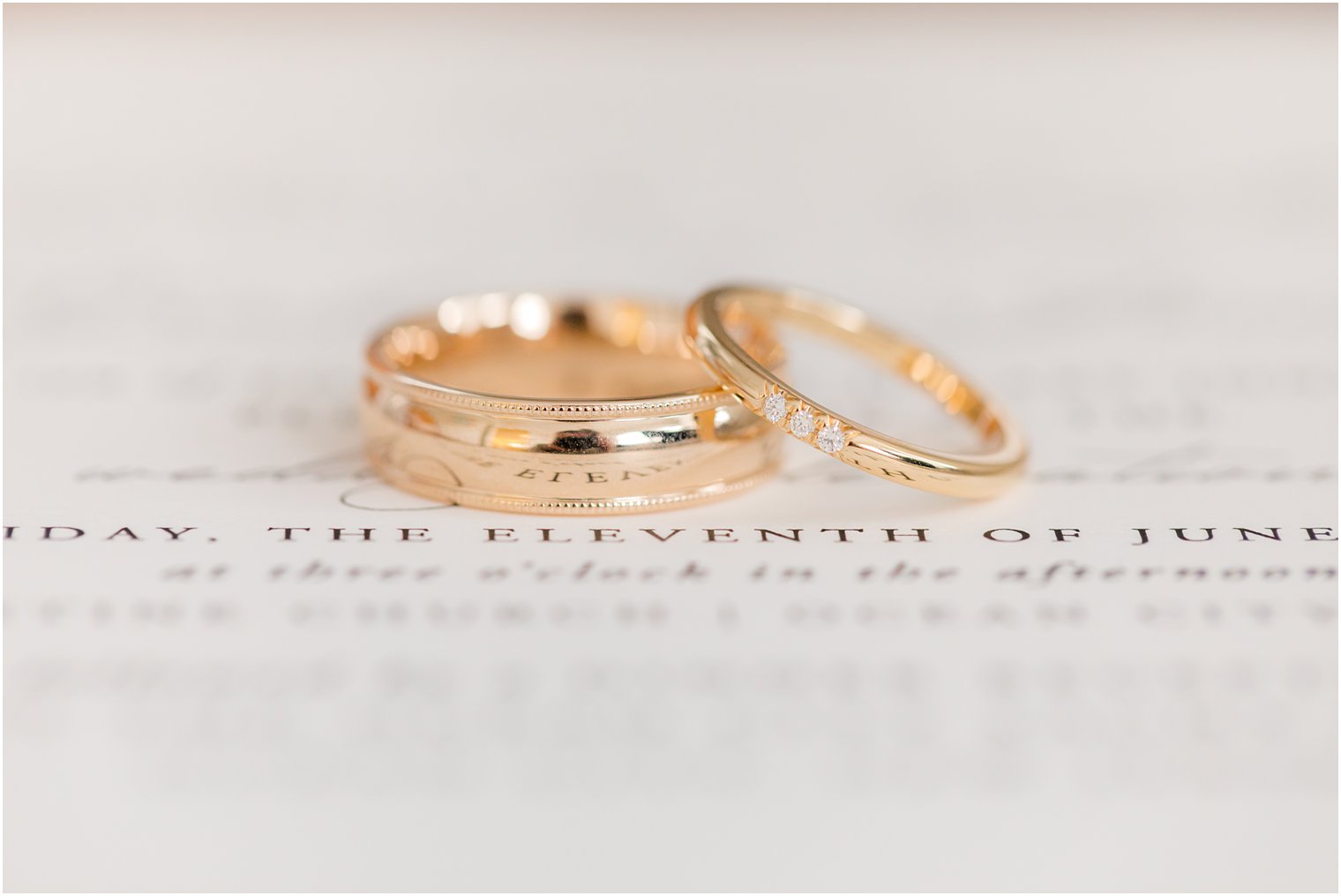 gold wedding bands rest on wedding invitation for NJ wedding