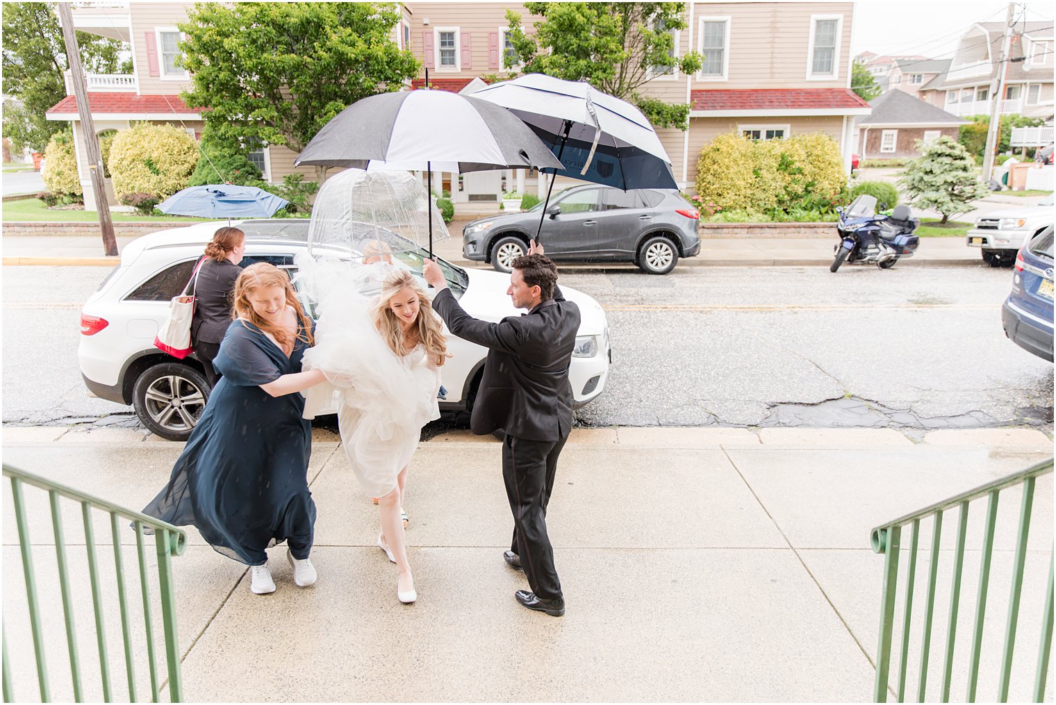 bride walks into church in the rain before New Jersey wedding 