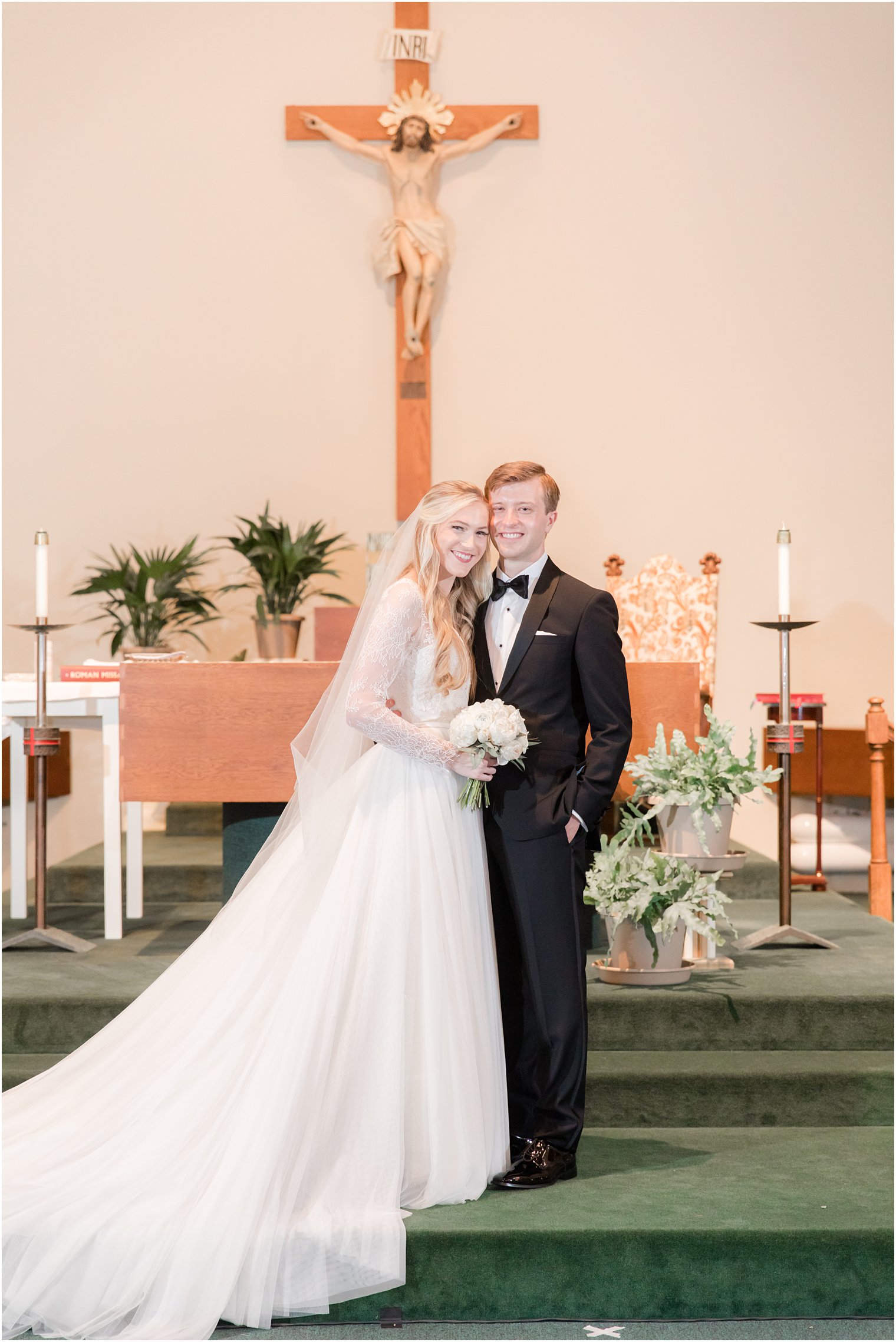 newlyweds stand together on altar in New Jersey church