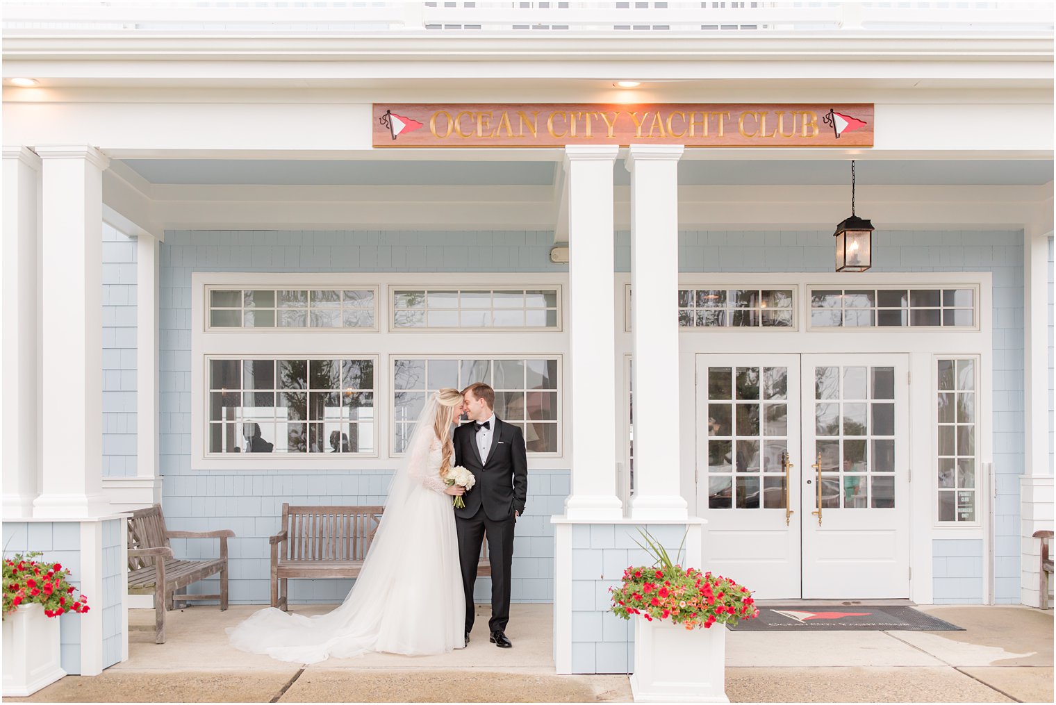 couple poses under awning at Ocean City Yacht Club on rainy wedding day