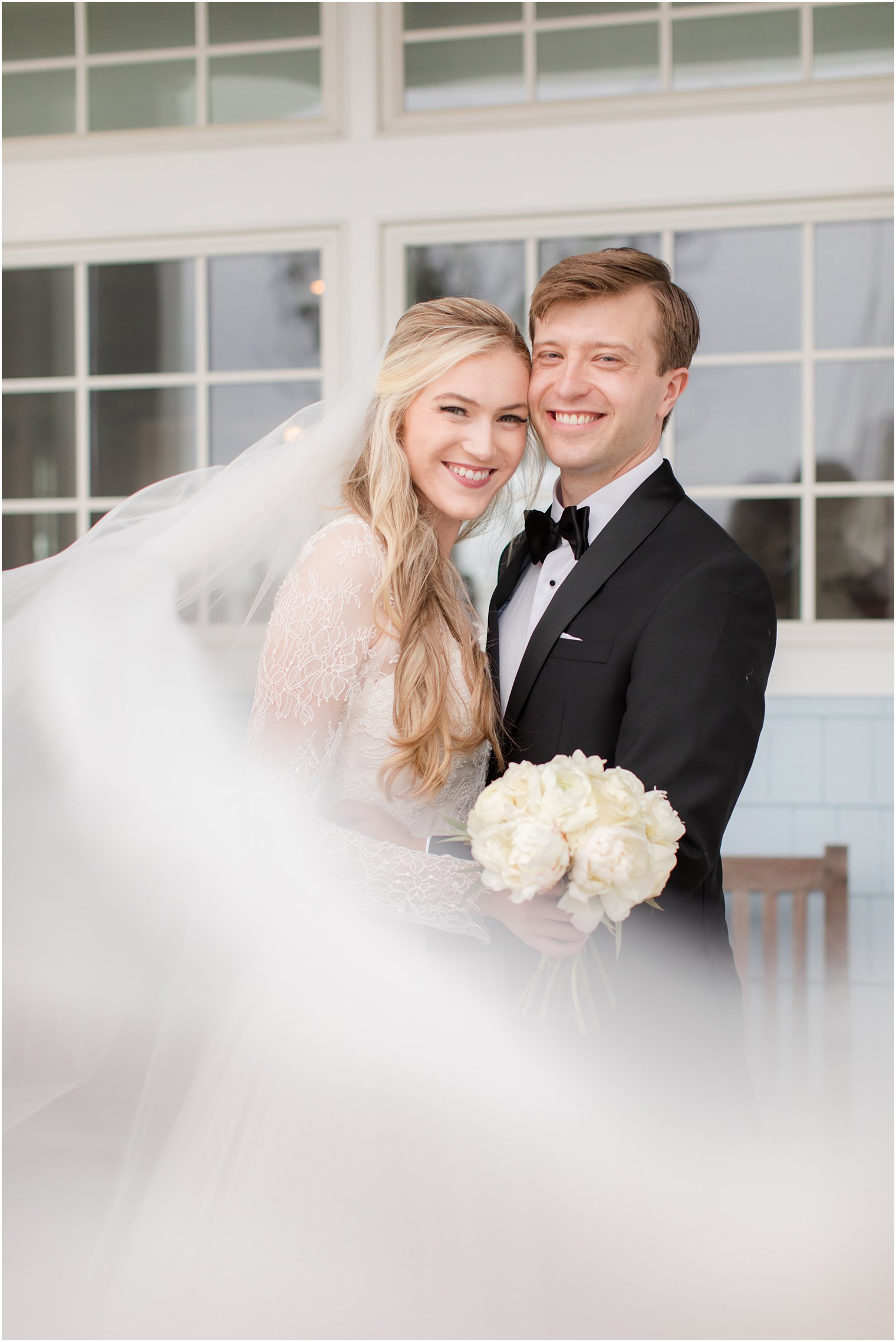 bride and groom lean heads together during classic NJ wedding portraits 