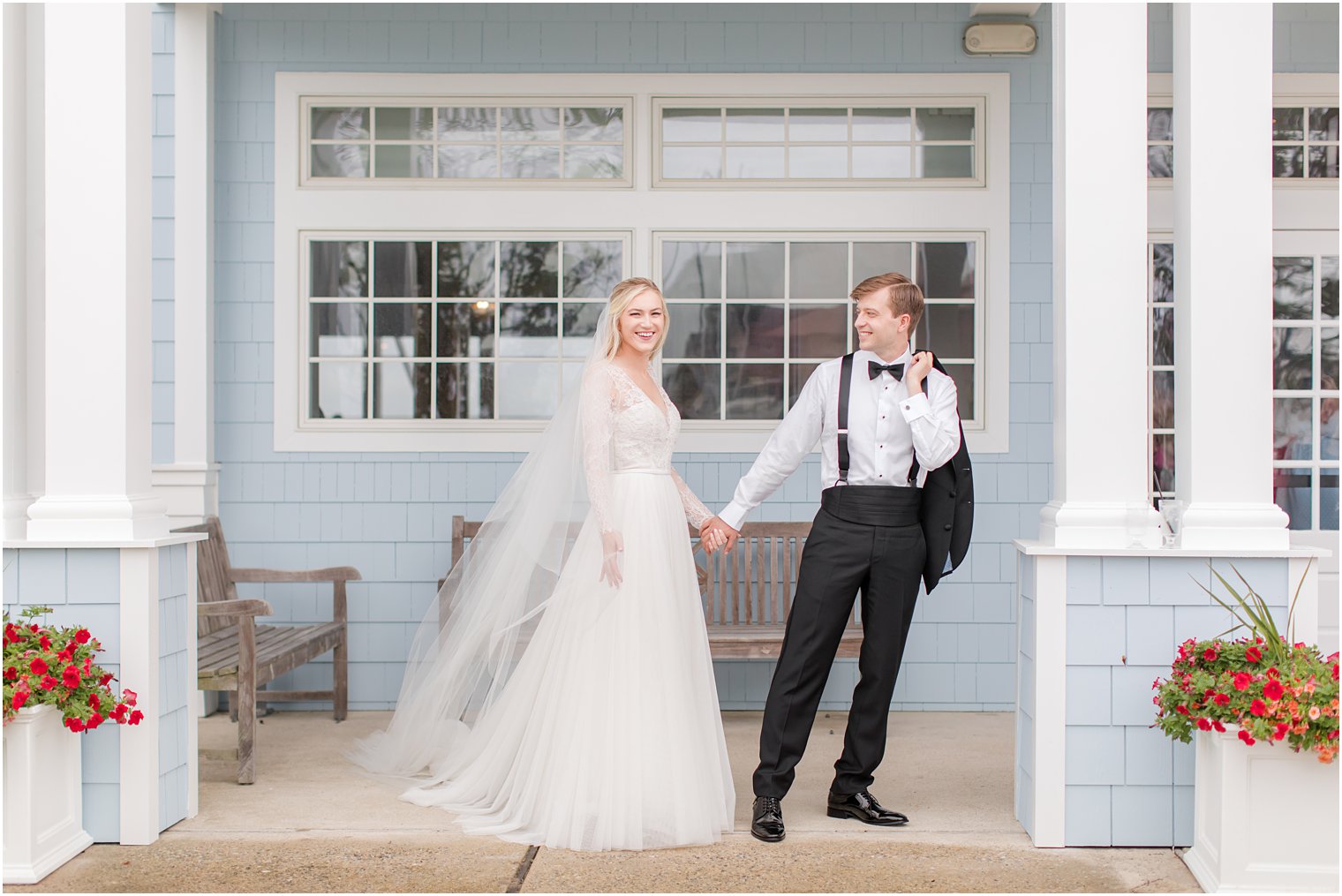 newlyweds hold hands walking along blue wall in NJ