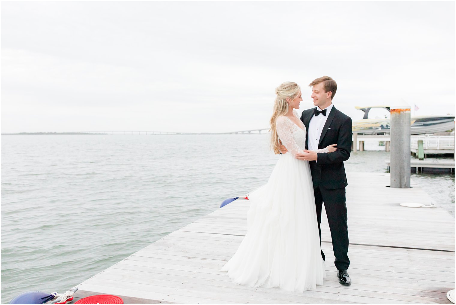 bride and groom hug on pier in Ocean City NJ