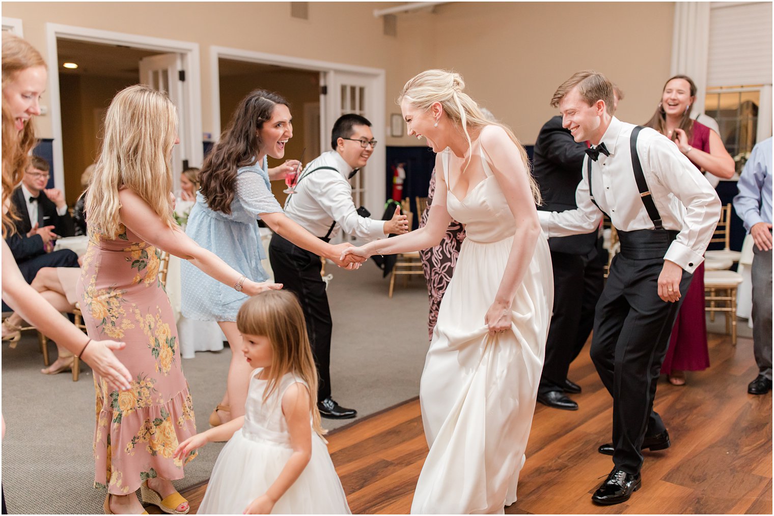 bride and groom dance with guests during wedding reception 