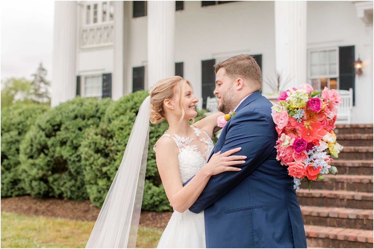 groom hugs bride outside Rosemont Manor