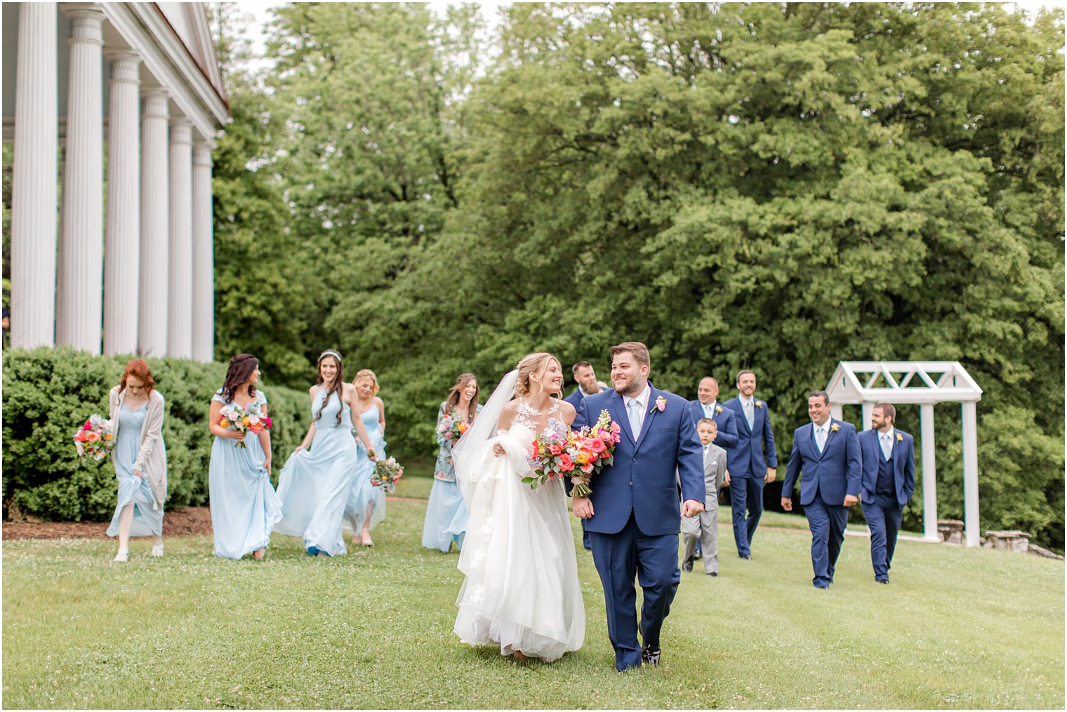 bride and groom walk with bridal party on lawn at Rosemont Manor