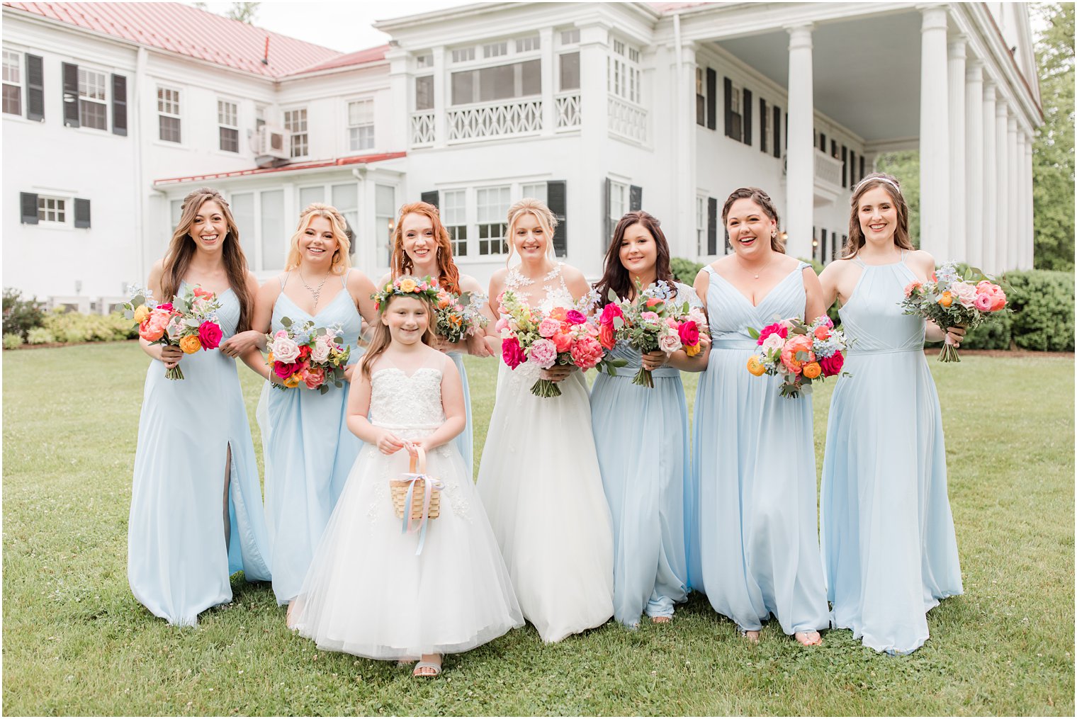bride poses with bridesmaids in light blue dresses at Rosemont Manor