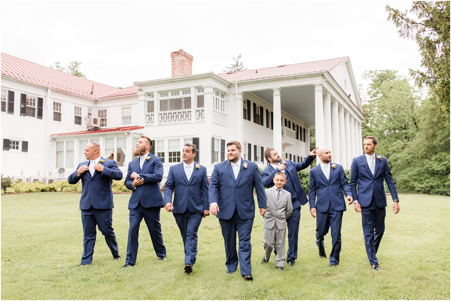 groom and groomsmen walk on lawn at Rosemont Manor