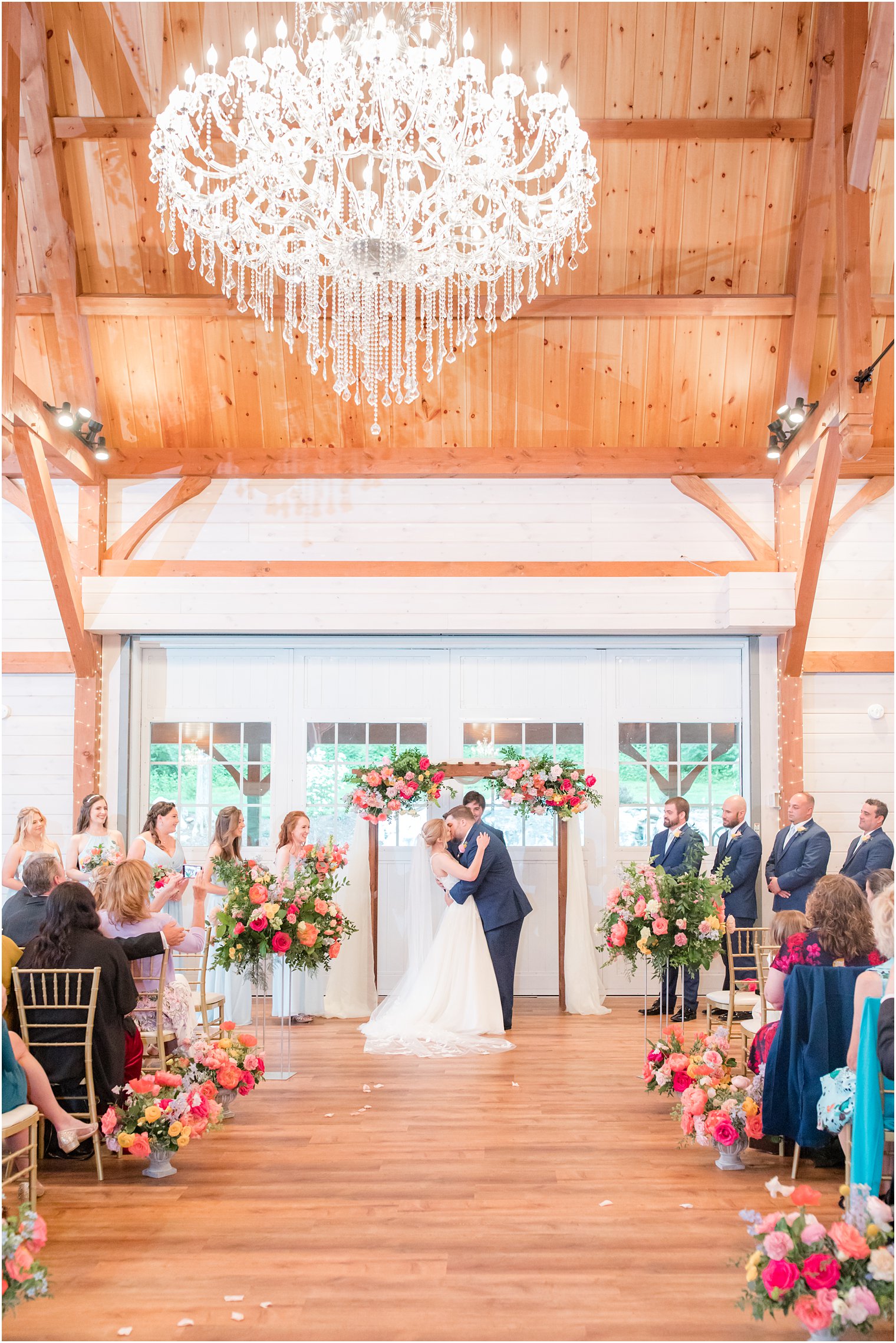 newlyweds kiss by floral arbor at Rosemont Manor