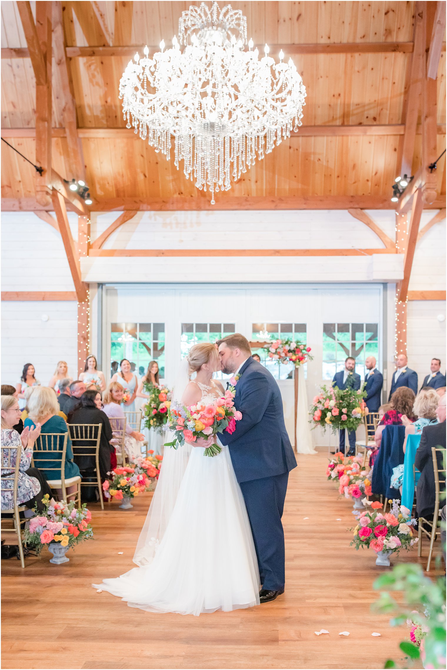bride and groom kiss at end of aisle in Rosemont Manor