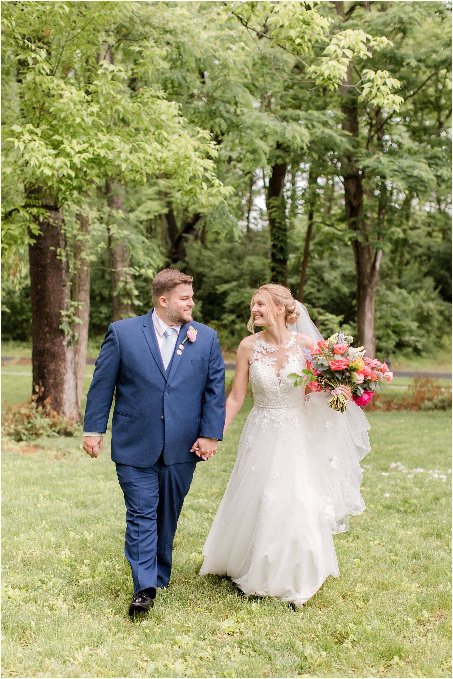 newlyweds walk through lawn at Rosemont Manor