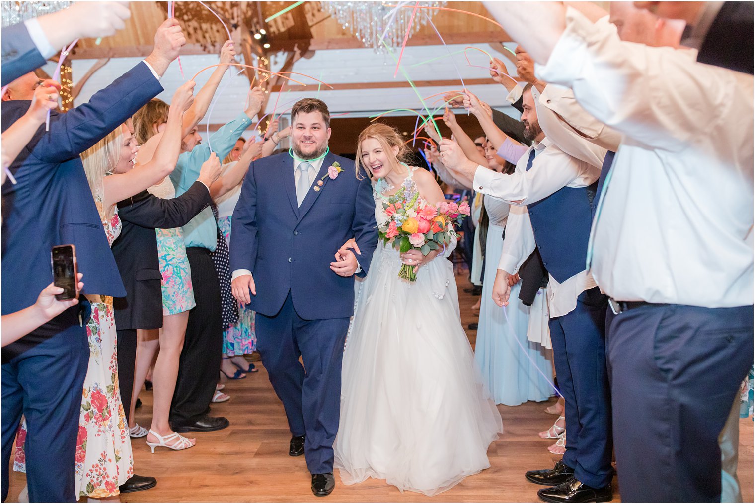 bride and groom walk through glow stick tunnel during wedding day exit 