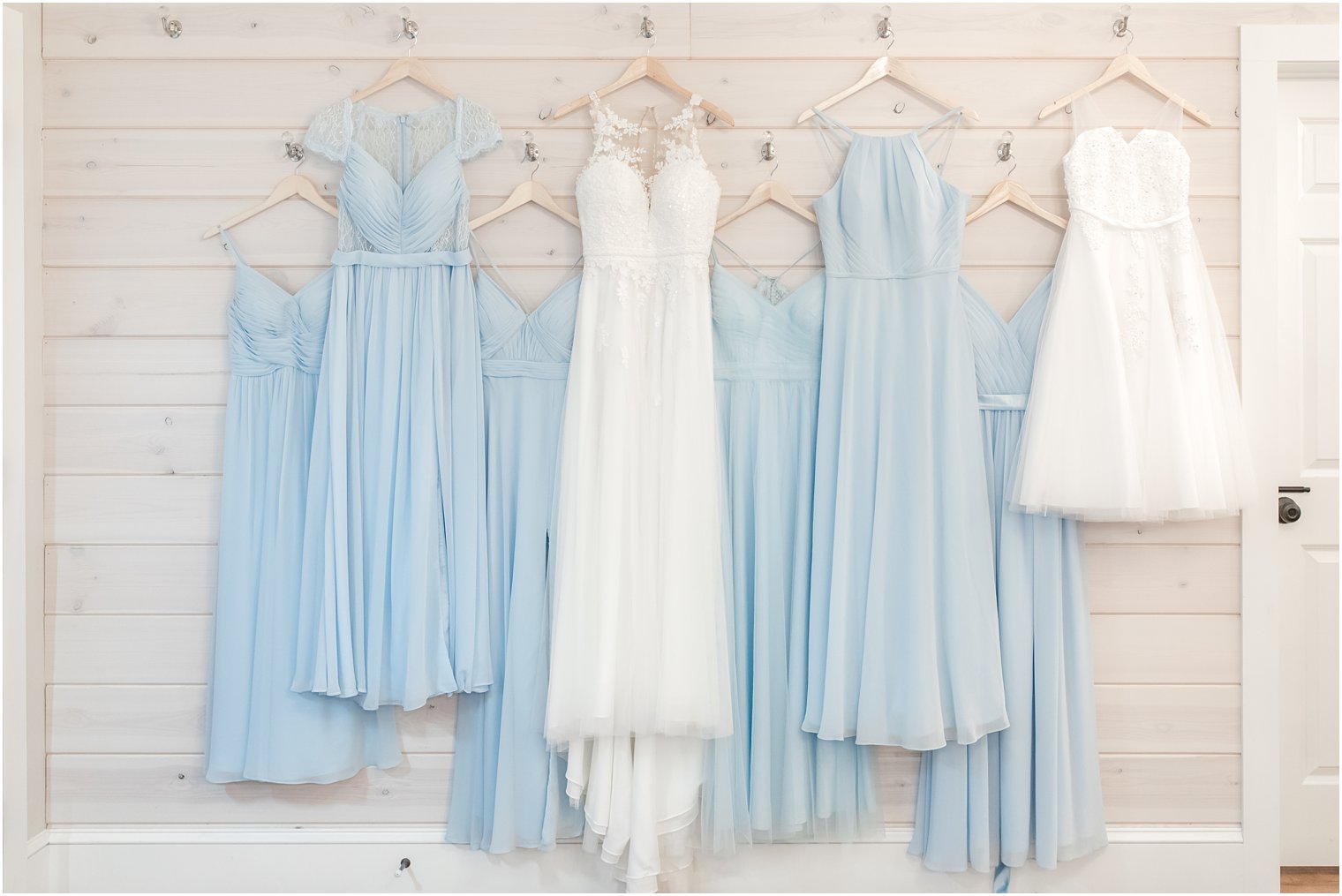 bride's dress hangs with pale blue bridesmaid gowns at Rosemont Manor
