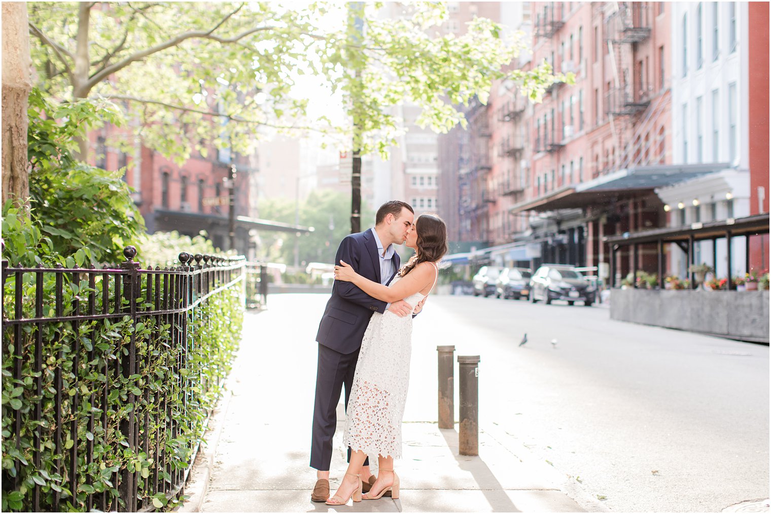 engaged couple kissing on the sidewalk in Duane Park in Tribeca