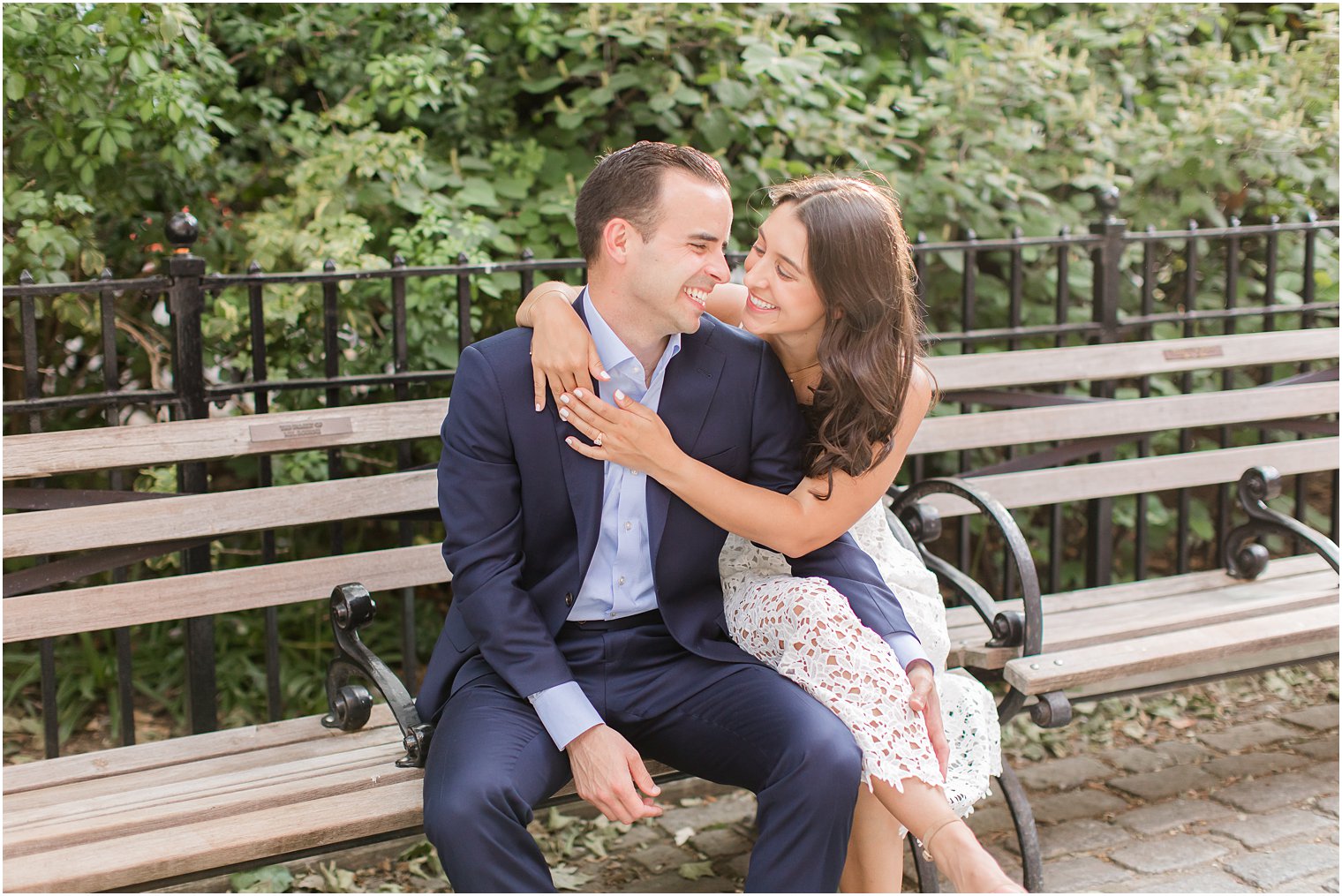 couple dressed up and sitting on a bench and smiling at each other