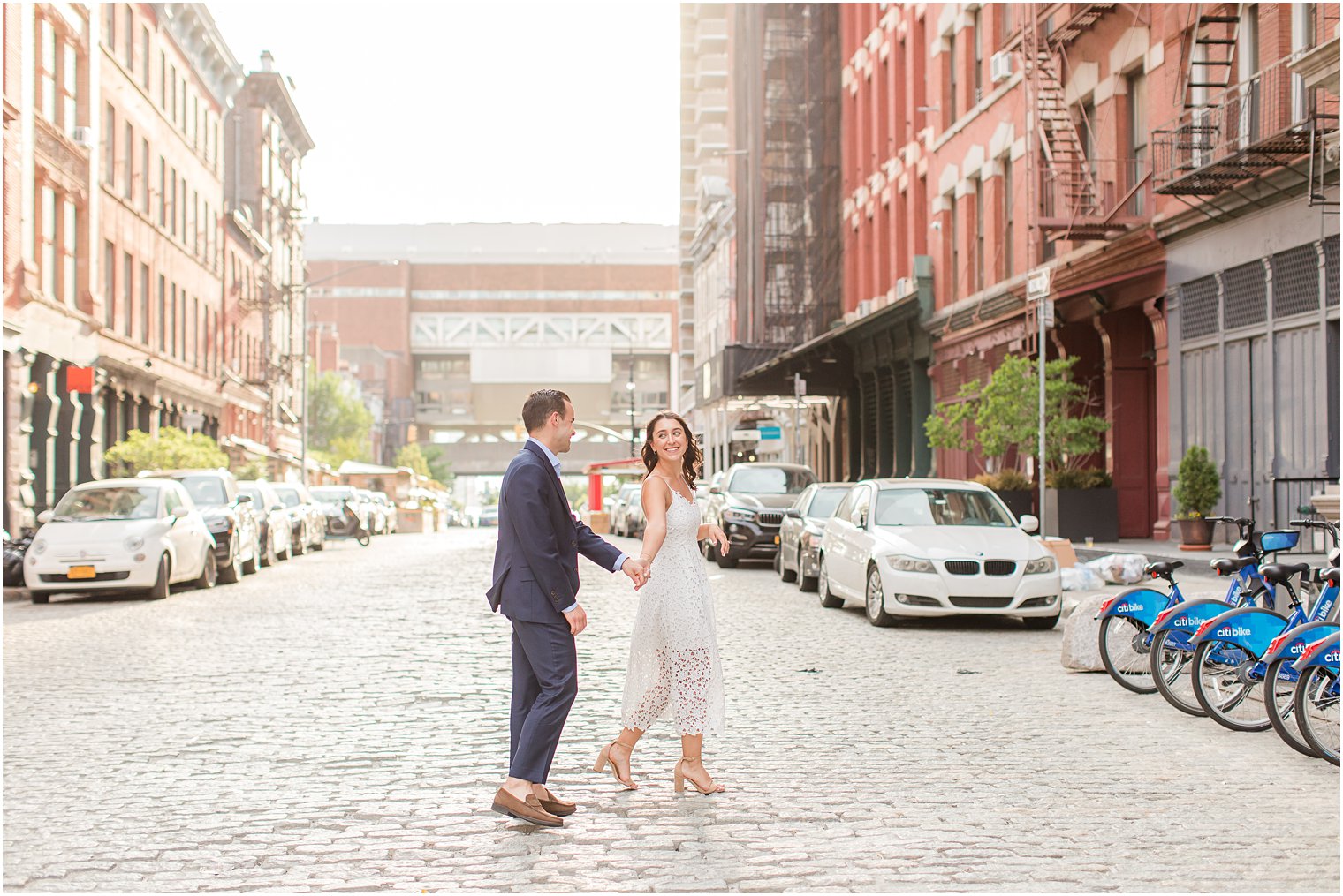 engaged couple walking on a cobblestone street in Tribeca
