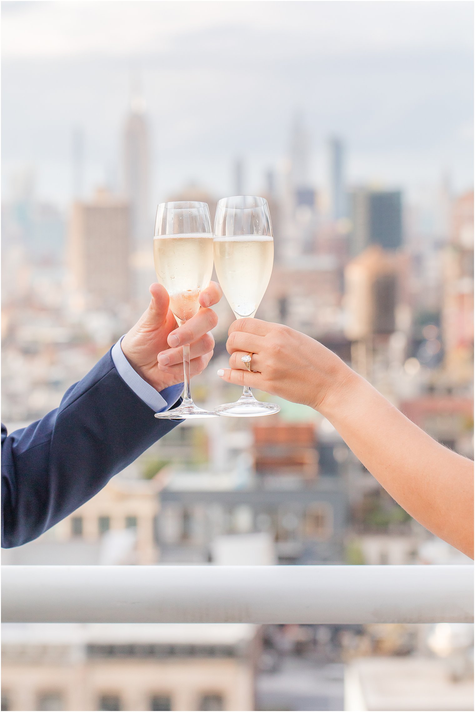 couple toasting champagne in front of NYC skyline 