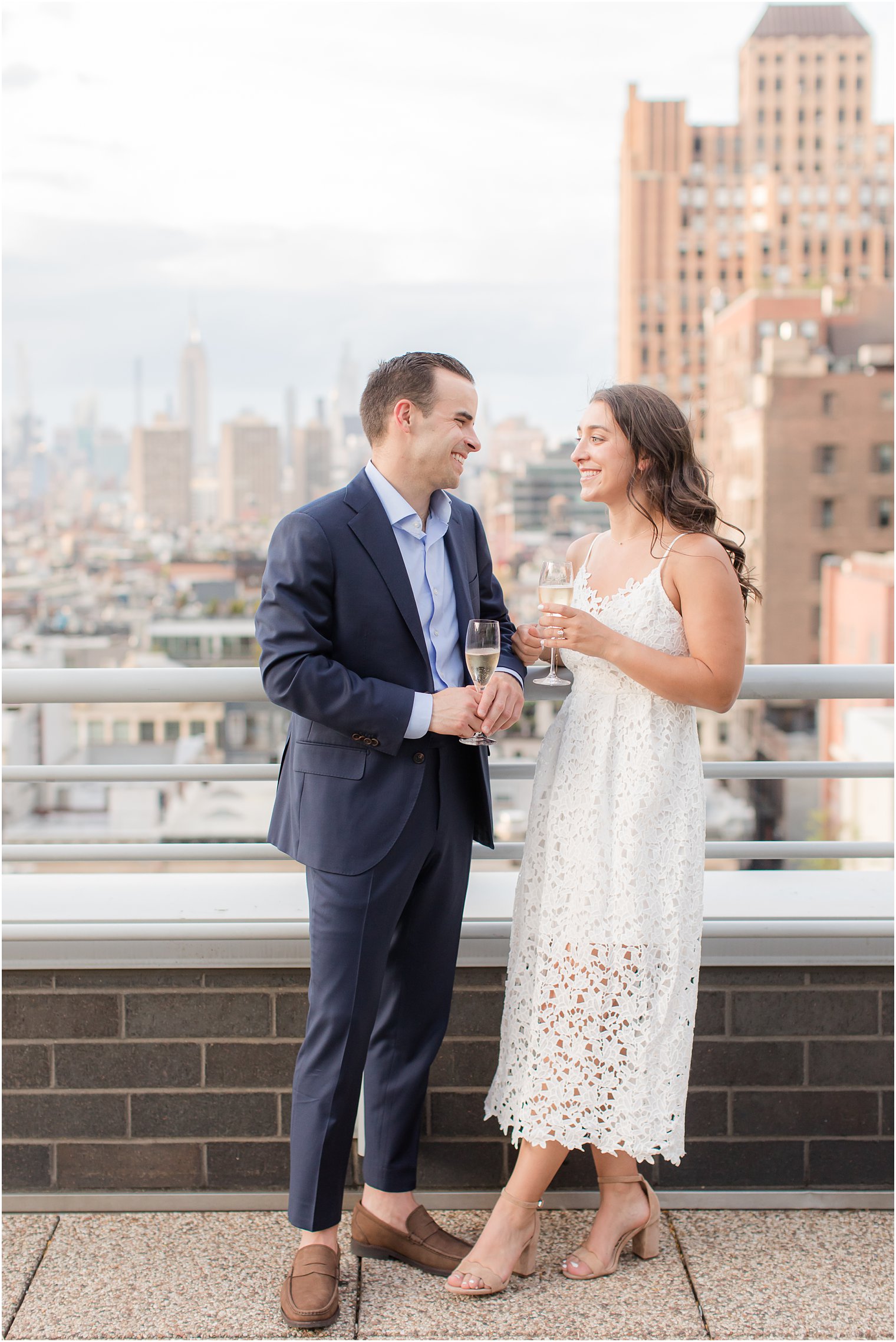 engaged couple opening bottle of champagne on Tribeca rooftop 