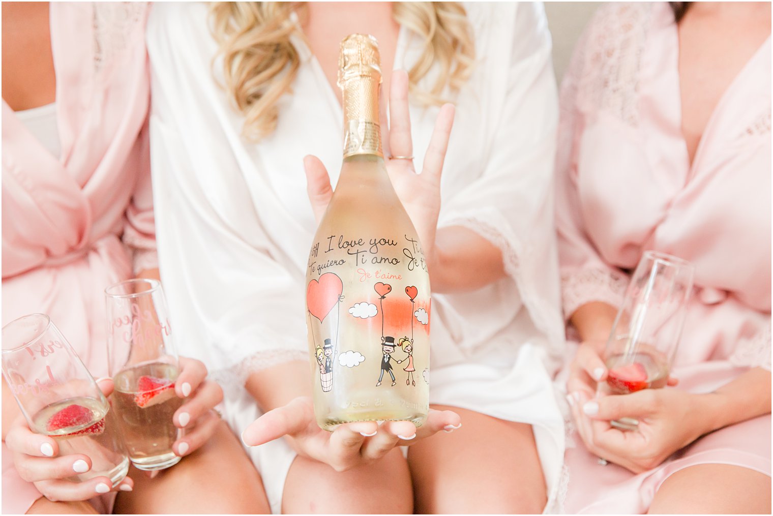 bride holds custom decorated bottle of champagne before wedding day 