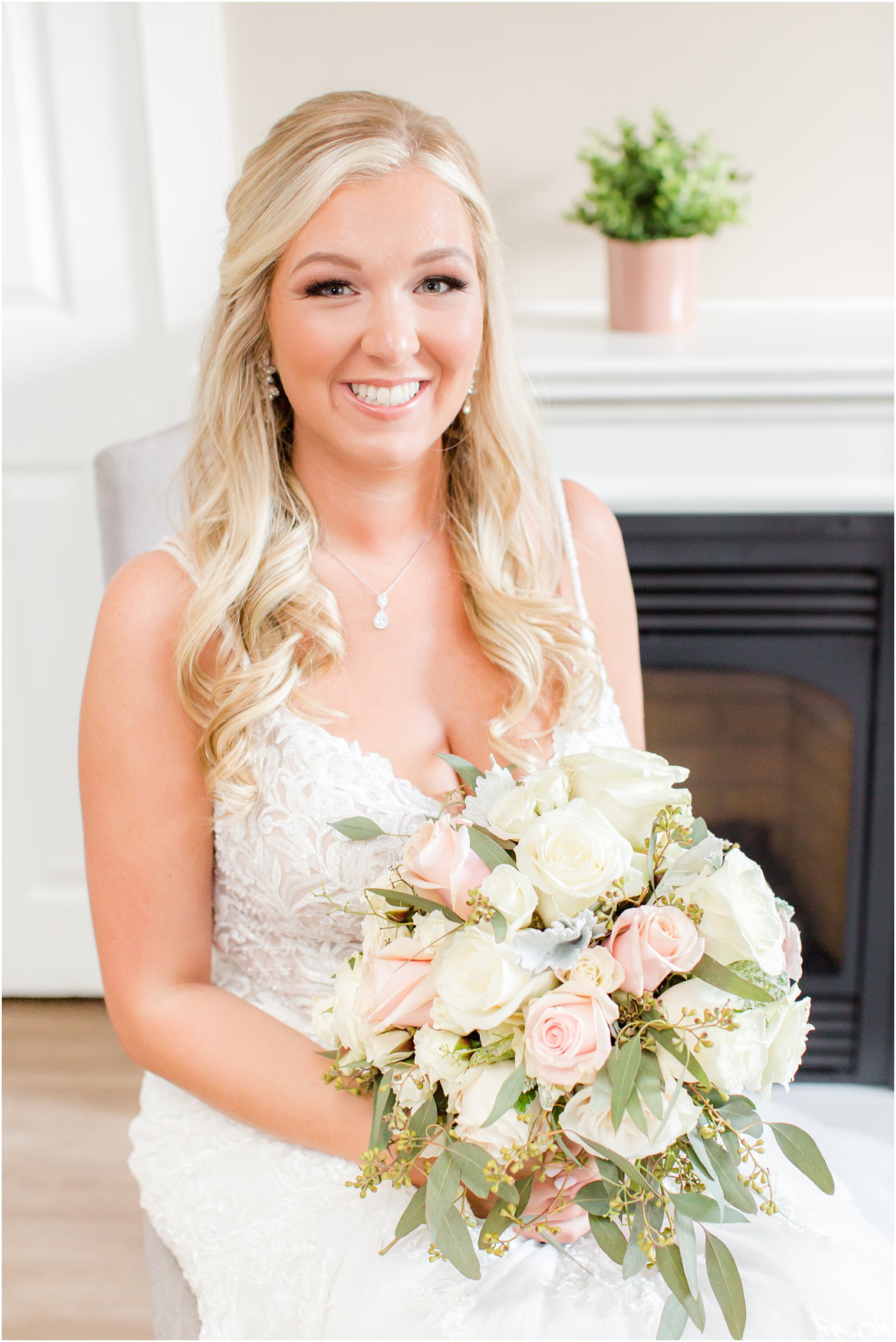 bride holds bouquet of ivory and pale pink roses before Brigalias wedding 