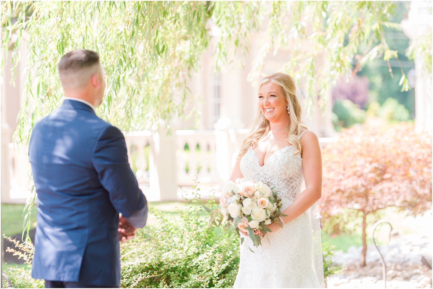 bride and groom smile during first look in New Jersey 