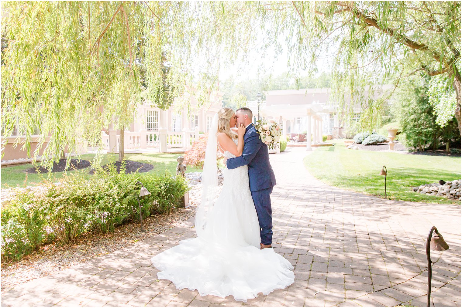 bride and groom kiss under weeping willow in New Jersey 