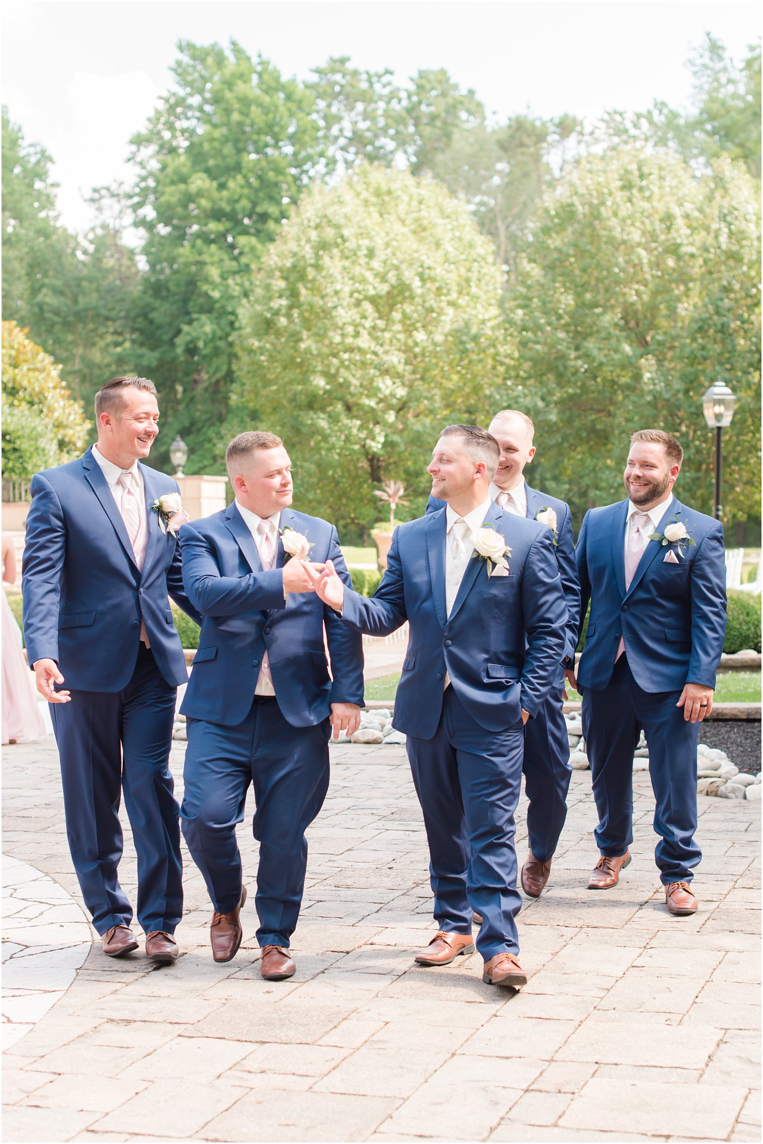 groom fist bumps best man during wedding photos in New Jersey 