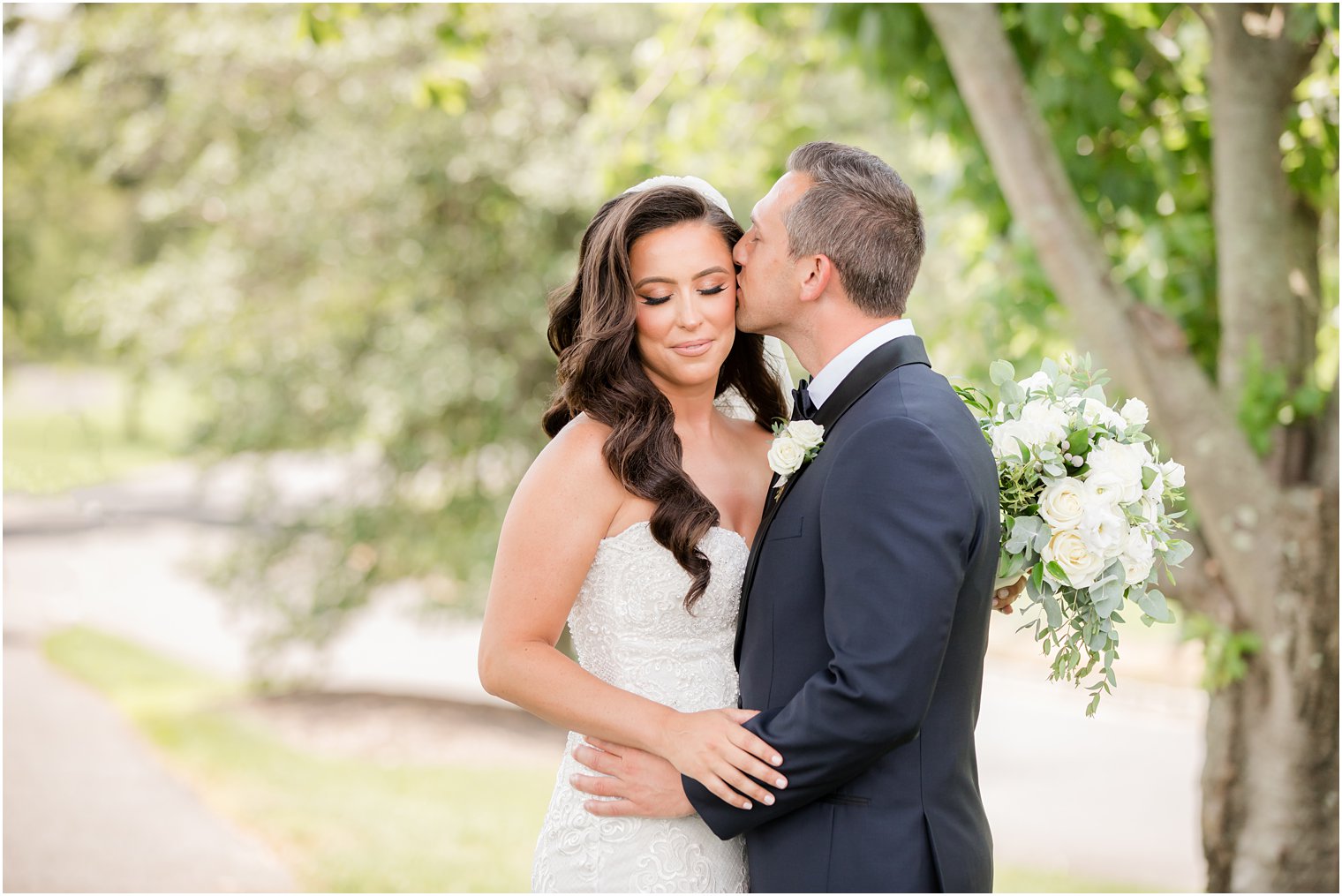 groom kisses bride's cheek during Navesink Country Club wedding photos