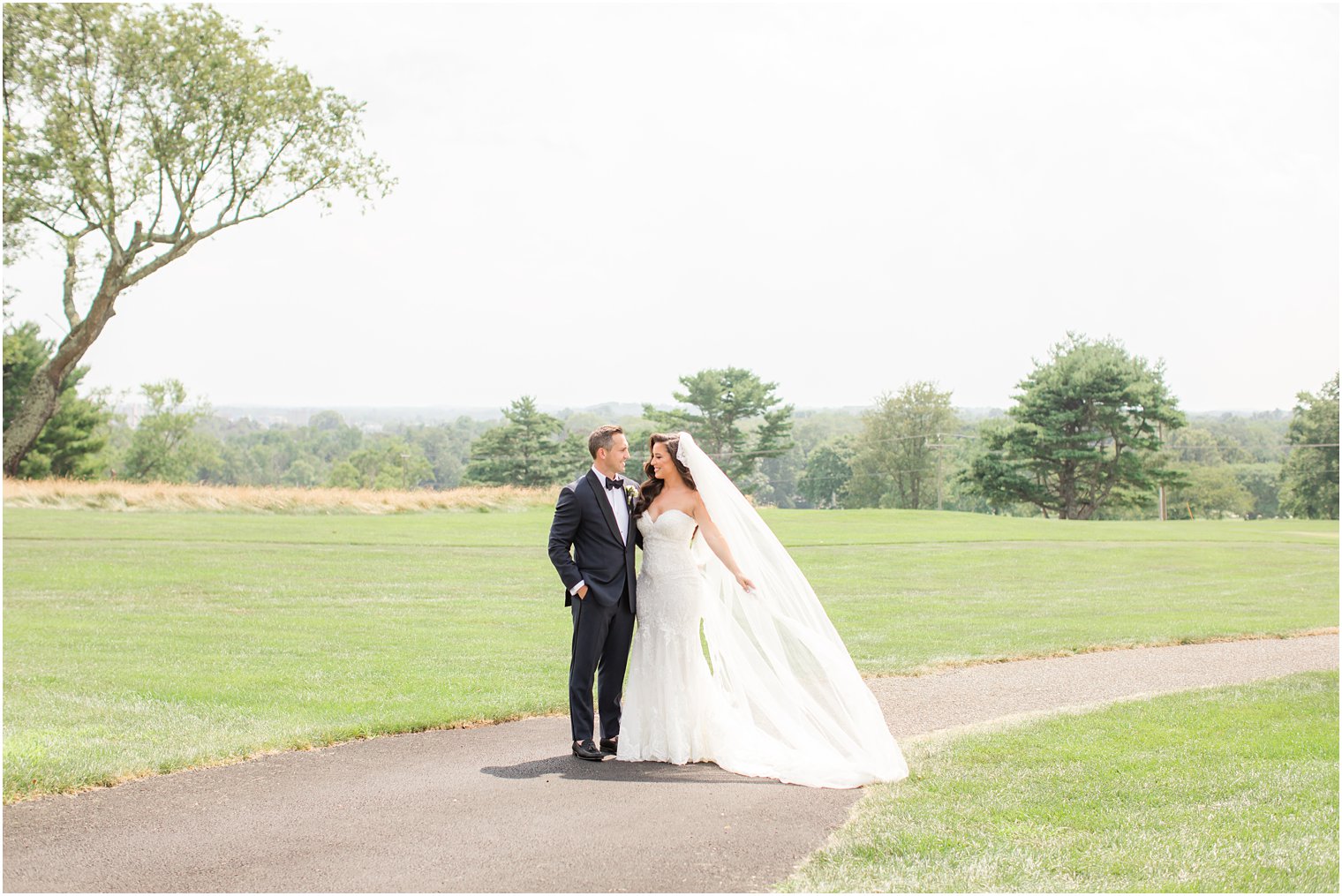 bride holds out veil during photos on course at Navesink Country Club