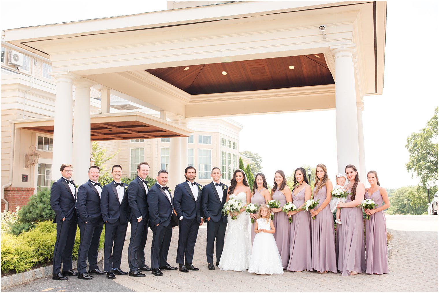 wedding party in black and mauve stand outside Navesink Country Club
