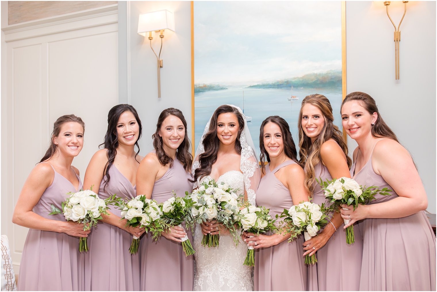 bridesmaids in mauve lean in with bride inside Navesink Country Club