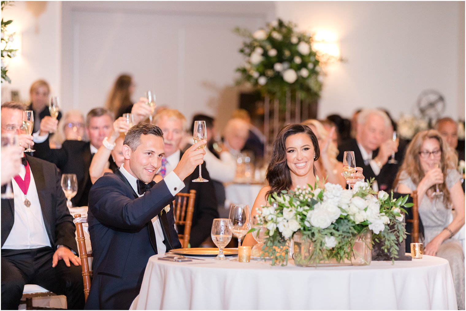 newlyweds lift champagne glasses during reception in Jersey