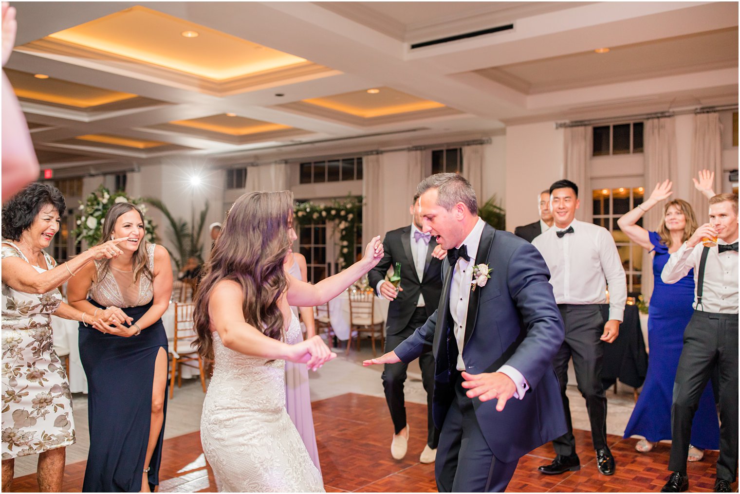 bride and groom dance during NJ wedding reception with guests