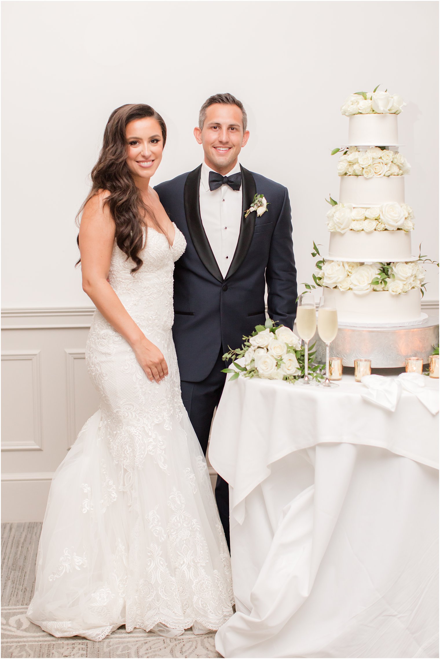 bride and groom pose with tiered wedding cake at Navesink Country Club