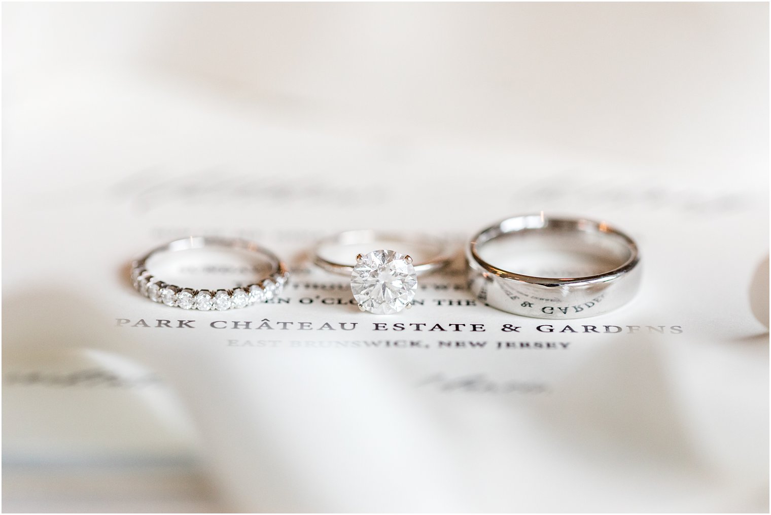 wedding bands lay on wedding invitation at Park Chateau Estate