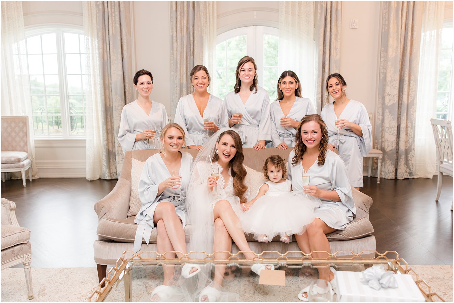 bride sits with bridesmaids and flower girls 